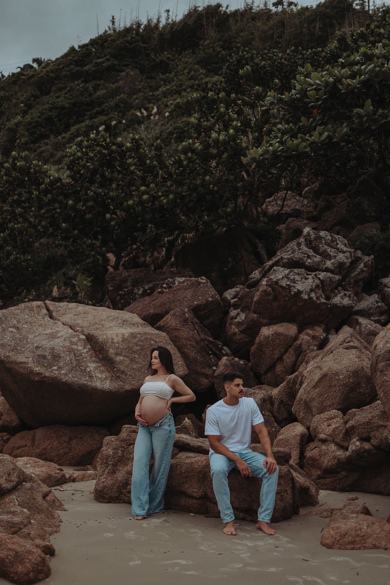 Casal gestante entre as pedras da praia